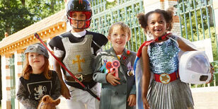 Vier kinderen verkleed als Ridder, prins, wetenschapper en astronaut. 